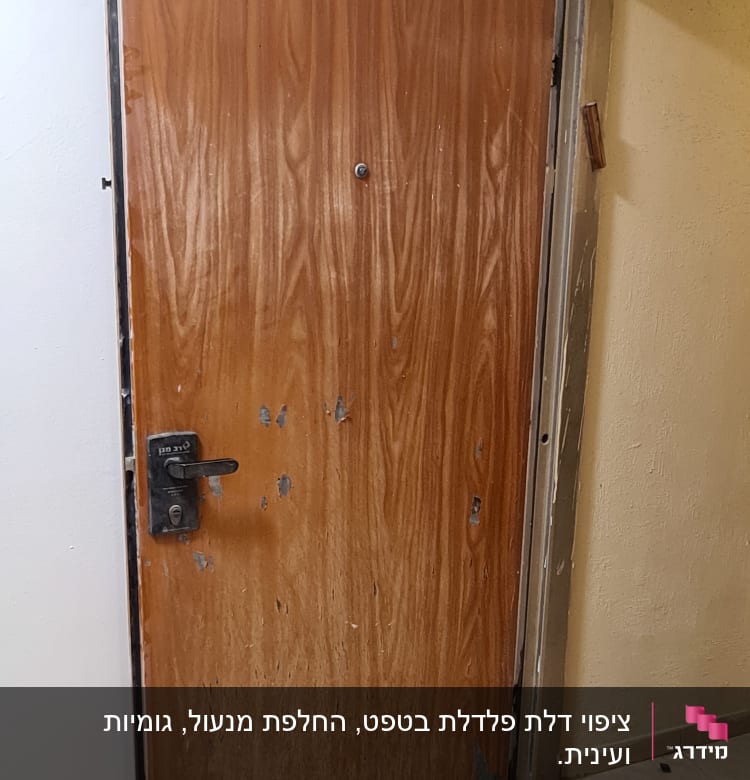 דלת עץ עם שריטות ופגמים, ידית מתכת שחורה